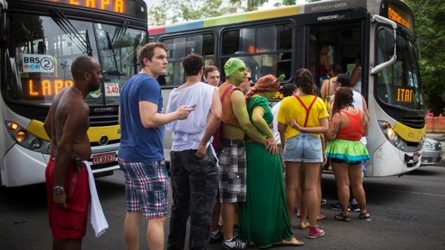 Foliões entram fantasiados em ônibus do Rio de Janeiro para chegar aos blocos de Carnaval
