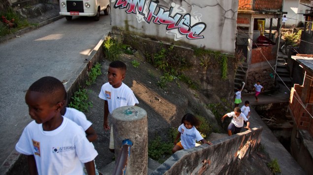 Crianças a caminho do ponto de leitura da comunidade Caracol, complexo da Penha, no Rio de Janeiro