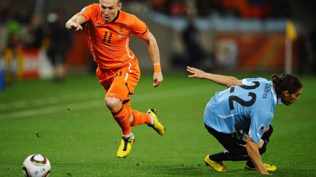 Arjen Robben passa pela marcação de Martin Caceres durante partida entre Holanda e Uruguai pelas Semifinais da Copa da África do Sul