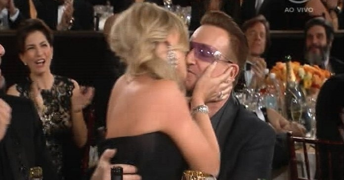 Uma das apresentadoras da festa, Amy Poehler dá um beijo no cantor Bono após receber o Globo de Ouro de melhor atriz em série cômica por Parks and Recreation