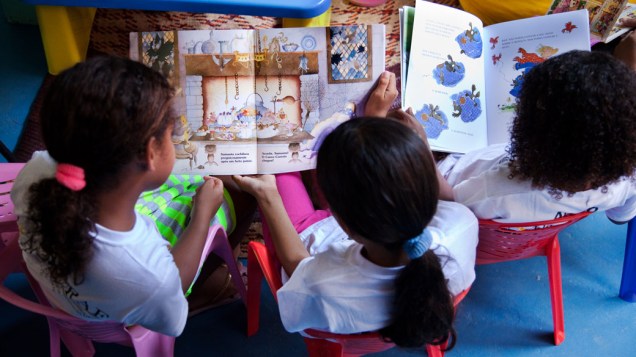 Crianças no ponto de leitura da comunidade Caracol, complexo da Penha, no Rio de Janeiro