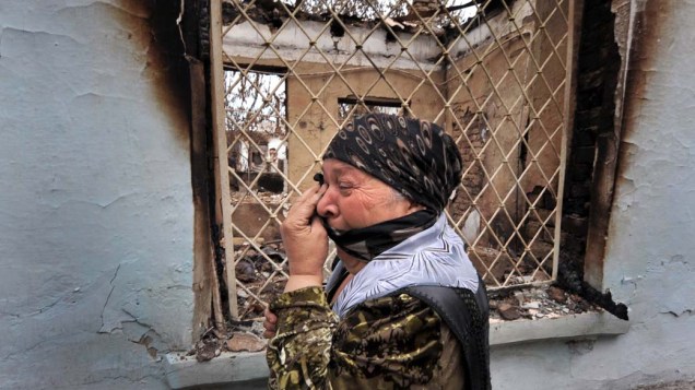 Mulher chora ao ver casas queimadas na cidade de Osh, no Quirguistão. Milhares de pessoas tem retornado ao país após buscarem exílio no Uzbequistão nas últimas semanas.