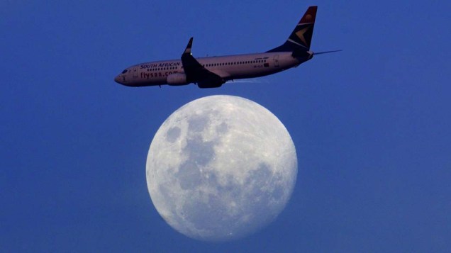 Um avião comercial saindo de Durban, na África do Sul, voa em frente à lua.