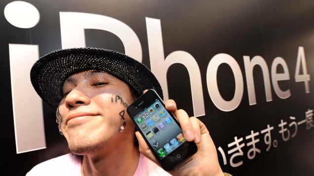 No primeiro dia de vendas do iPhone 4 no Japão, homem segura seu exemplar em frente a uma loja em Tóquio.