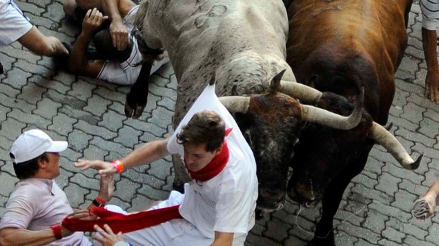 Pessoas participam da corrida de touros em Pamplona, na Espanha, como parte da tradicional festa de San Fermín