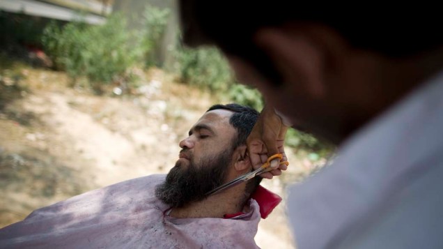 Homem paquistanês tem sua barba aparada nas ruas da cidade de Islamabad