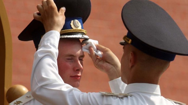 Soldado limpa o suou do rosto do colega, em Moscou. As temperaturas na Rússia ultrapassaram os 35ºC