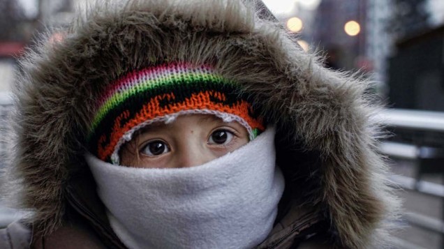 Criança se protege do frio em Santiago, no Chile. O país enfrenta o pior inverno dos últimos três anos