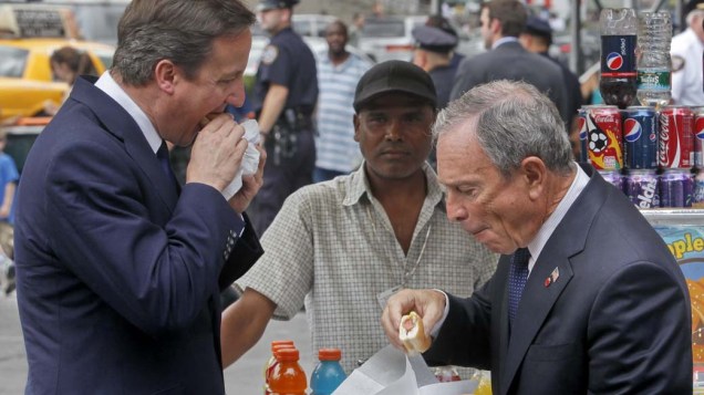 O primeiro-ministro britânico, David Cameron, e o prefeito de Nova York, Michael Bloomberg, comem cachorros-quente durante a primeira visita do britânico aos Estados Unidos