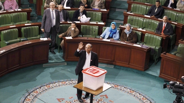 O novo presidente da Tunísia, Moncef Marzuki, acena na Assembleia Constituinte