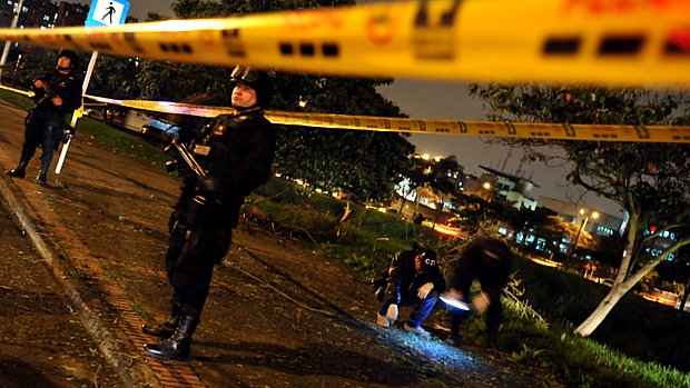 Policiais do esquadrão antibomba colombiano investigam área onde um artefato explodiu perto da embaixada dos EUA no país