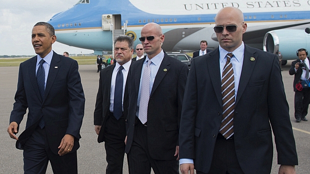 Barack Obama desembarca do Força Aérea Um acompanhado por agentes do Serviço Secreto