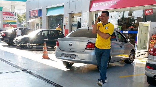 Suspenso do PT, deputado estadual Luiz Moura fala ao telefone em posto de gasolina invadido por black blocs horas antes da abertura da Copa