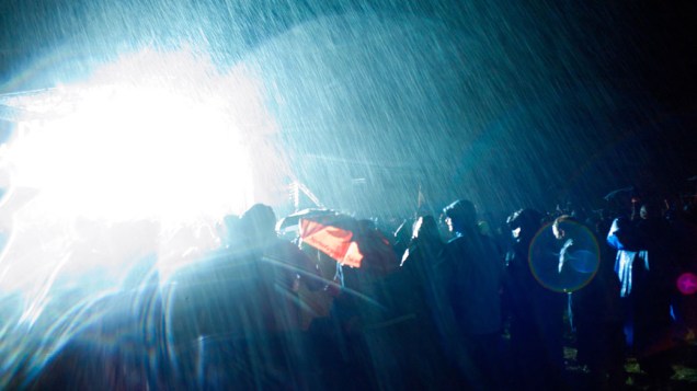 Debaixo de chuva forte, escoteiros acompanham o encerramento do 22º Acampamento Mundial Escoteiro, em Rinkaby, na Suécia