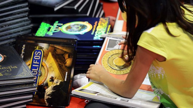 Garota brinca com livro interativo na 22ª Bienal de Livros de São Paulo no Anhembi