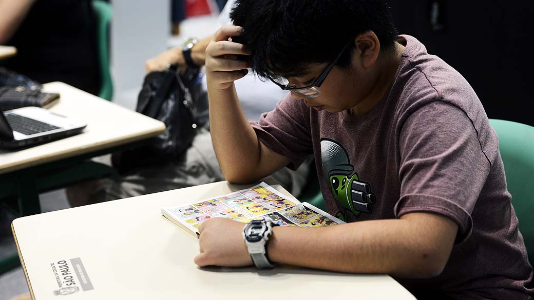 Garoto lê durante a 22ª Bienal do Livro de São Paulo no Anhembi
