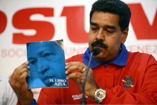 O presidente venezuelano, Nicolás Maduro, mostra um livro do ex-líder do país, Hugo Chávez, durante uma coletiva de imprensa na sede do Partido Socialista, em Caracas, em 21 de outubro de 2013