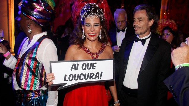 Narcisa segura a placa "Ai, que loucura!" no baile de Carnaval do Copacabana Palace, no Rio