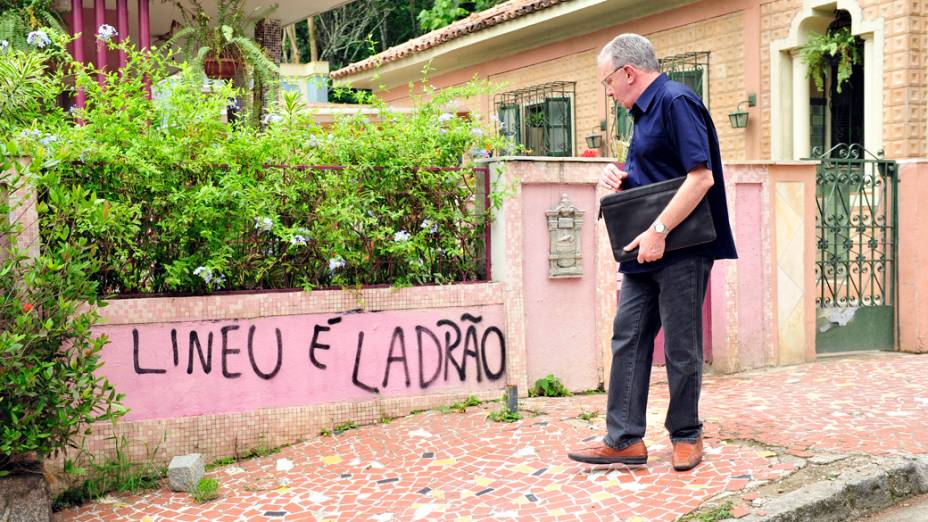    Lineu ( Marco Nanini ) passa em frente ao muro da casa, onde está pichado: "Lineu é ladrão"