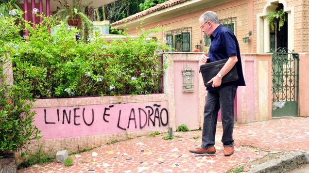   Lineu ( Marco Nanini ) passa em frente ao muro da casa, onde está pichado: "Lineu é ladrão"