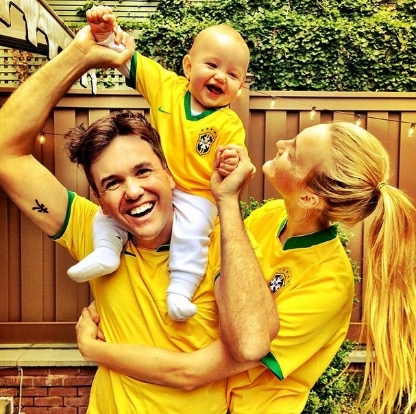 A modelo Carol Trentini, o marido e o filho deles posam vestidos com o uniforme da Seleção Brasileira.