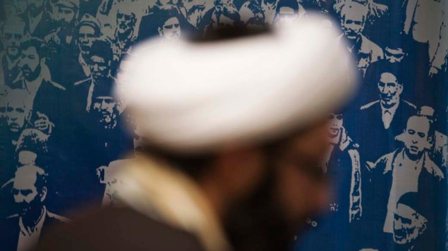 Abdolreza Tarzi está na frente de um banner durante o seu registro como candidato para as eleições parlamentares do Irã, em Teerã