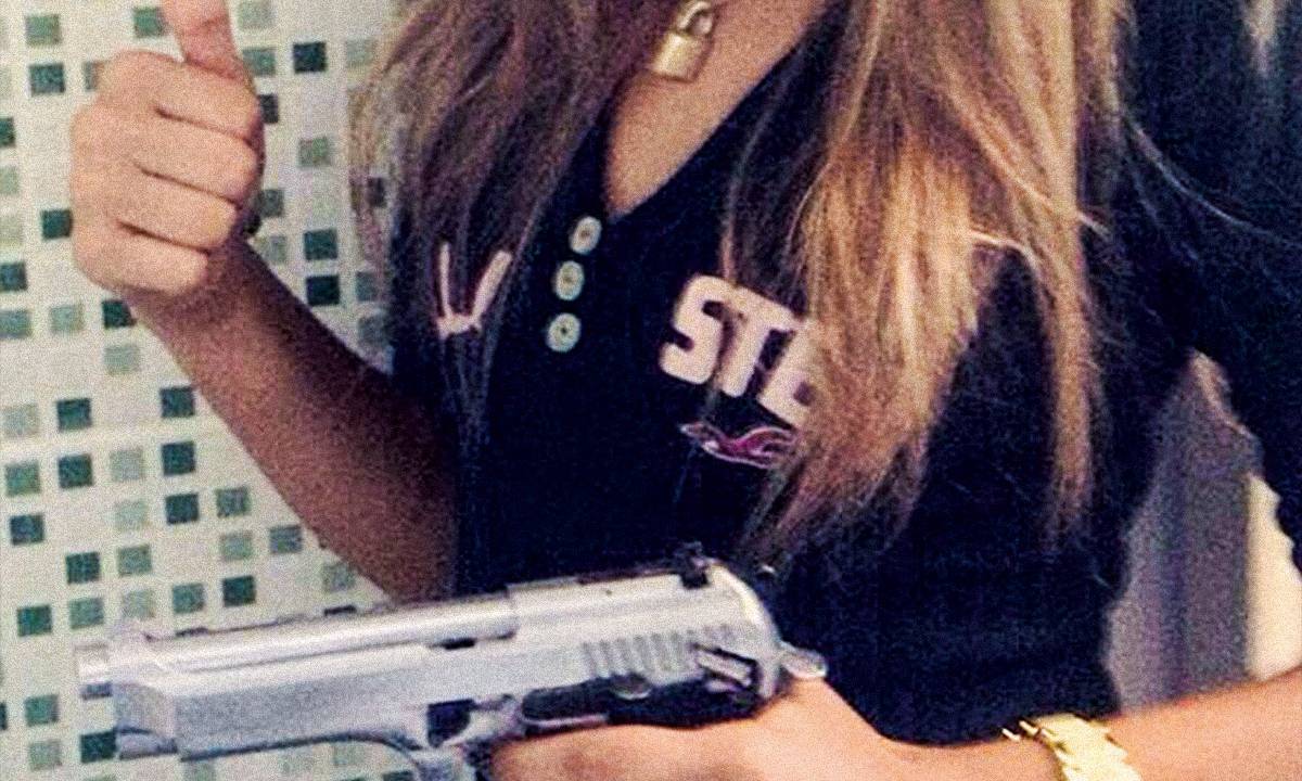 A menor empunha uma arma em foto divulgada por traficantes: atração por bailes funk, drogas e más companhias