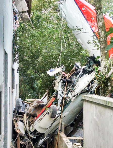 Destroços do helicóptero são vistos sobre um imóvel na Grande São Paulo