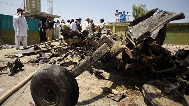 Moradores observam destroços de avião que colidiu com outro durante treinamento e caiu em área residencial no Paquistão
