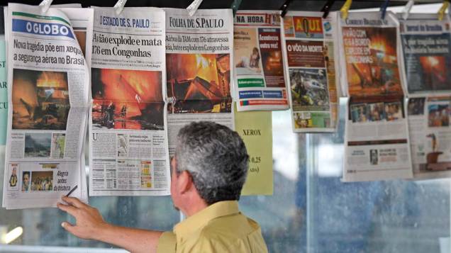 No dia seguinte, leitor observa jornais com notícias sobre o acidente