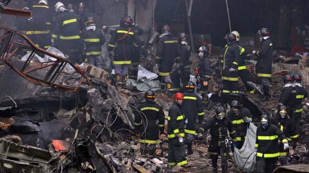 Bombeiros trabalham no resgate de vítimas do acidente com o avião Airbus A-320, da TAM, que se chocou contra um prédio da empresa