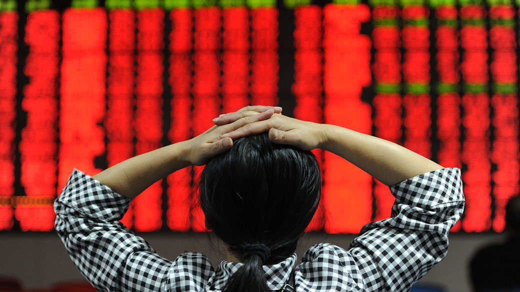 Investidor chinês acompanha o preço das ações em painel eletrônico em Hefei, China