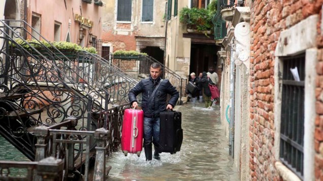 Italiano caminha por rua alagada no período da Acqua Alta