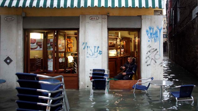 Comerciante observa rua alagada em Veneza, Na Itália