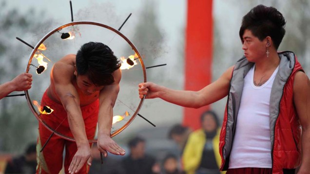 Na China, homem passa por anel cercado por fogo e facas durante festival no condado de Linquan, na província de Anhui