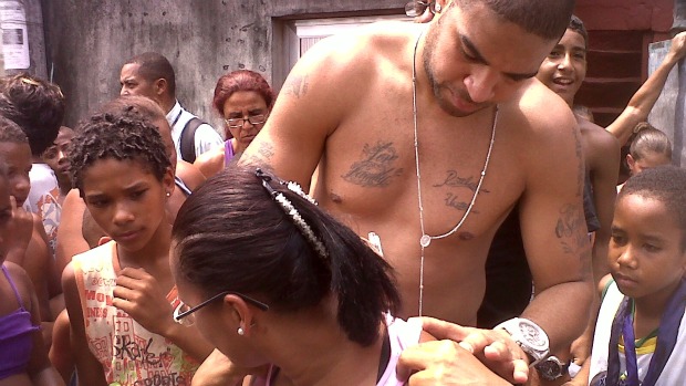 Adriano dá autógrafo em sua primeira visita a Vila Cruzeiro depois da invasão da favela pelas forças de segurança