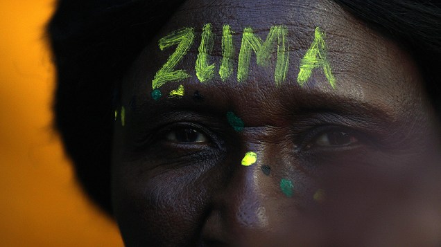 Partidário com a testa pintada, escrito o nome do Presidente Jacob Zuma fora do Tribunal Gauteng South High em Joanesburgo, África do Sul
