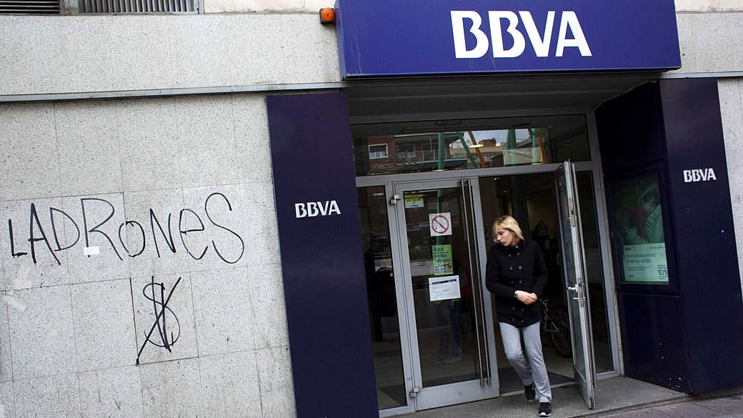 mulher sai de agência do banco espanhol BBVA em Madri