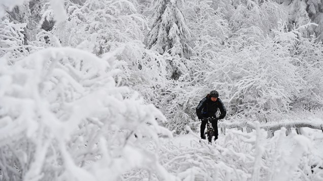 Homem anda de bicicleta em meio à neve, na cidade de Taunus, na Alemanha
