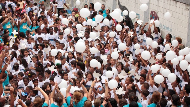 Crianças da escola Afonso Várzea soltam balões brancos ao som de "Sementes do Amanhã", de Gonzaguinha, durante festa de fim de ano no Complexo do Alemão