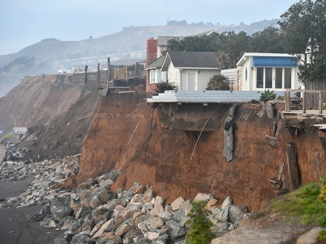 Casas são vistas à beira do abismo, na Califórnia (EUA). Tempestades e fortes ondas causadas pelo El Niño têm intensificado o processo de erosão na região, colocando moradias em risco