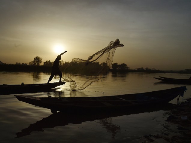 Homem pesca na margem do rio Niger, em Niamey, nesta tarde (21)