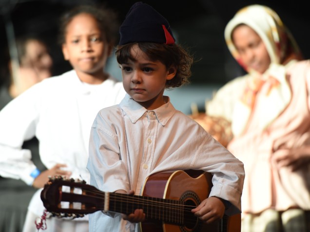 Criança toca violão durante a apresentação do grupo "Casa Ilha da Madeira - Folclore e etnografia da região autônoma da madeira", durante a 20ª Festa do Imigrante, em São Paulo