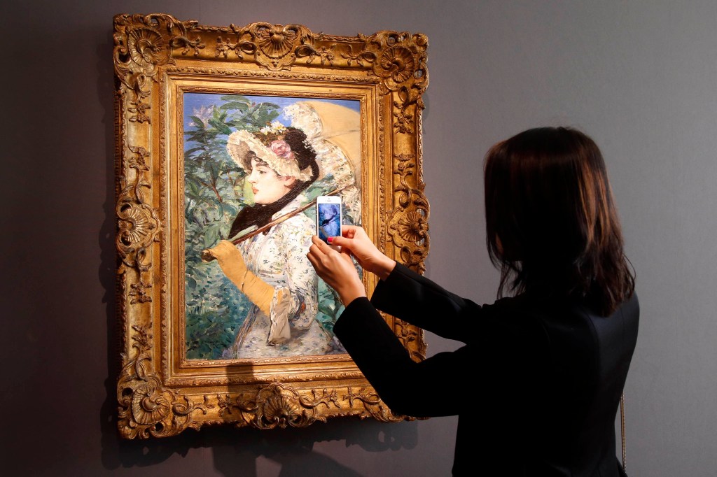 Visitante tira foto do quadro ‘A Primavera’, do pintor francês Edouard Manet, durante apresentação na casa de leilões Christie's