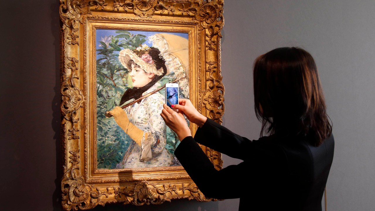 Visitante tira foto do quadro ‘A Primavera’, do pintor francês Edouard Manet, durante apresentação na casa de leilões Christie's