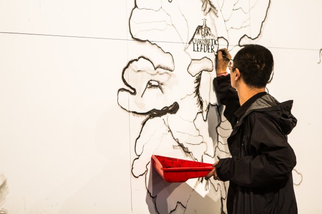 O artista chinês Qiu Zhijie finaliza a obra Map (Mapa), que foi traçada na parede da rampa que sai área Parque e que desaparecerá assim que a exposição for encerrada, em dezembro