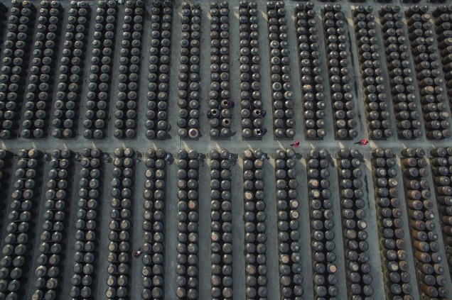 Trabalhadores caminham entre barris de vinagre e molho de soja em uma fábrica de Zhenjiang, na China