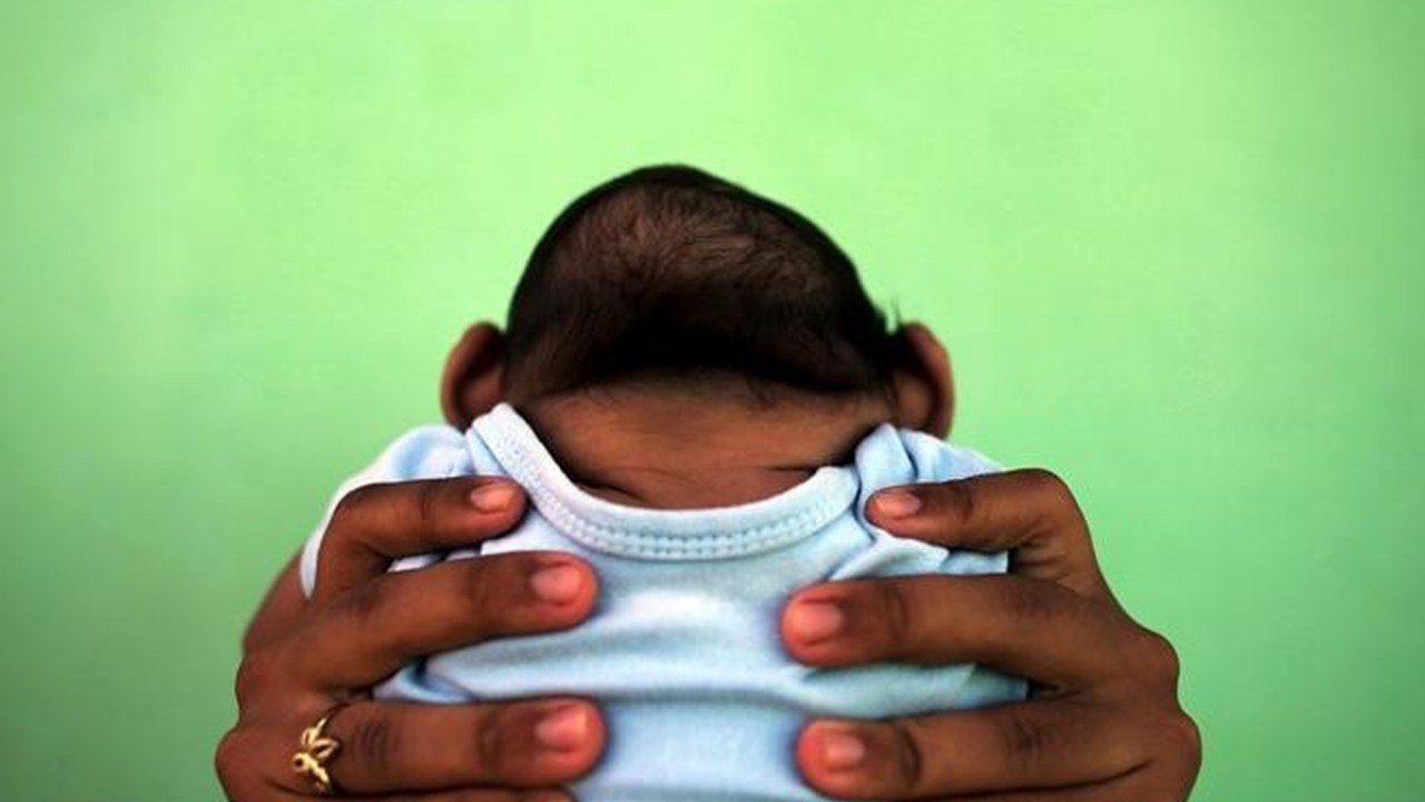 Jackeline, de 26 anos, segura o filho Daniel, de 4 meses, que nasceu com microcefalia em Olinda
