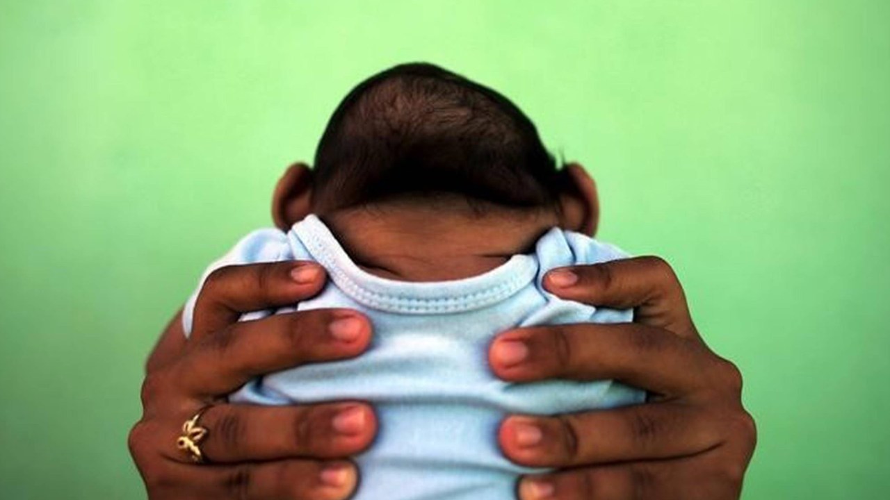 Jackeline, de 26 anos, segura o filho Daniel, de 4 meses, que nasceu com microcefalia em Olinda