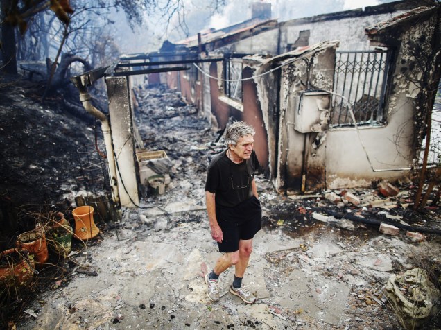 Homem observa os restos de sua casa que foi queimada em um incêndio em Tokai, Cidade do Cabo (África do Sul) - 04/03/2015